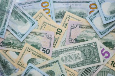 Masada farklı adaylıklarda büyük miktarlarda Amerikan doları var. Doğal ışık altında birçok dolarlık banknotlar.