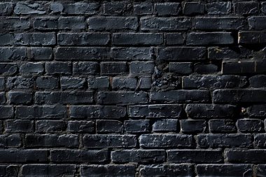 Eski tuğla duvarın resmi siyah renge boyanmış. Yakın plan. Arkaplan veya haritalama için arkaplan dokusu