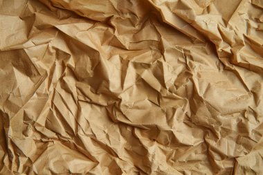 Buruşuk kahverengi kağıdın fotoğrafı. Kapatın. Arkaplan veya haritalama için arkaplan dokusu