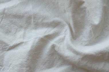 Arka plan olarak beyaz renkli gri tekstil peçetesi. Katlanmış dekoratif mutfak pamuğu havlusu kapat.