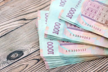 Ahşap arka planda modern tasarımı olan büyük miktarda Ukrayna yapımı 100 Hryvnia para faturası. Finansal konsept, iş ücretleri