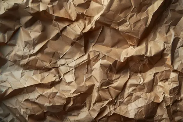 Buruşuk kahverengi kağıdın fotoğrafı. Kapatın. Arkaplan veya haritalama için arkaplan dokusu