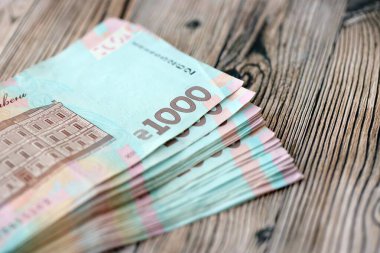 Ahşap arka planda modern tasarımı olan büyük miktarda Ukrayna yapımı 100 Hryvnia para faturası. Finansal konsept, iş ücretleri
