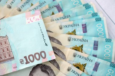 Beyaz ahşap masa üzerinde modern tasarımı olan büyük miktarda Ukrayna yapımı 100 Hryvnia para faturası. Finansal konsept, iş ücretleri