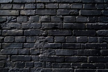 Eski tuğla duvarın resmi siyah renge boyanmış. Yakın plan. Arkaplan veya haritalama için arkaplan dokusu