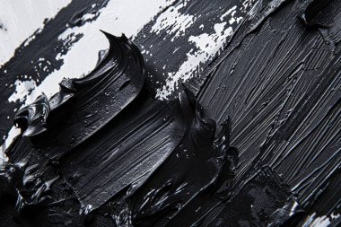 Düz yüzeydeki birçok koyu siyah akrilik yağlı boya lekesinin fotoğrafı. Arkaplan veya haritalama için arkaplan dokusu