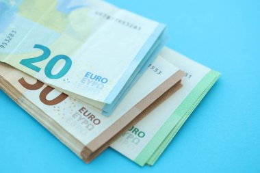 Büyük meblağda, mavi arka planda yüz yirmi-elli euro para faturası.