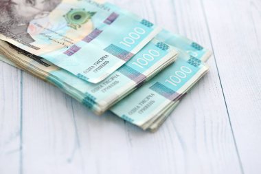 Beyaz ahşap masa üzerinde modern tasarımı olan büyük miktarda Ukrayna yapımı 100 Hryvnia para faturası. Finansal konsept, iş ücretleri
