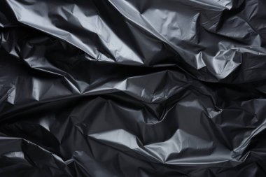 Siyah selofan çöp torbası dokusunun işlenmiş kolajı. Pankart, arkaplan veya 3B haritalama için doku
