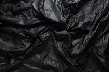 Siyah selofan çöp torbası dokusunun işlenmiş kolajı. Pankart, arkaplan veya 3B haritalama için doku