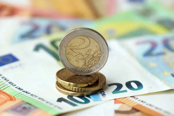 İki avroluk para, büyük miktarlarda farklı avro banknotlarının üzerinde yatıyor.