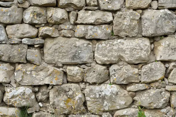 Eski gri ve kahverengi taş duvarın fotoğrafı. Arkaplan veya haritalama için arkaplan dokusu