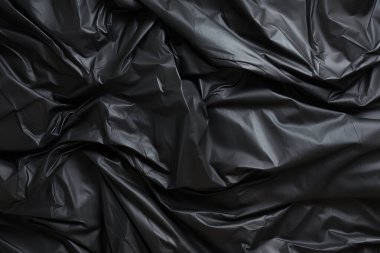 Siyah selofan çöp torbası dokusunun işlenmiş kolajı. Pankart, arkaplan veya 3B haritalama için doku