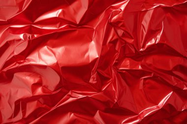 İşlenmiş kırmızı plastik selofan yüzey dokusu kolajı. Pankart, arkaplan veya 3B haritalama için doku