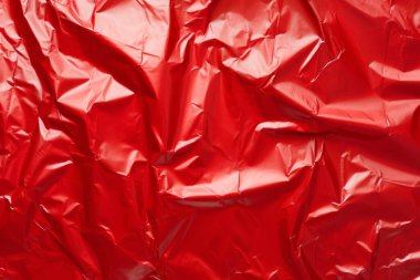 İşlenmiş kırmızı plastik selofan yüzey dokusu kolajı. Pankart, arkaplan veya 3B haritalama için doku