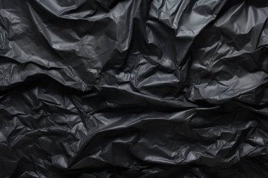Siyah selofan çöp torbası dokusunun işlenmiş kolajı. Pankart, arkaplan veya 3B haritalama için doku