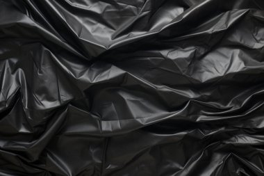 Siyah selofan çöp torbası dokusunun işlenmiş kolajı. Pankart, arkaplan veya 3B haritalama için doku