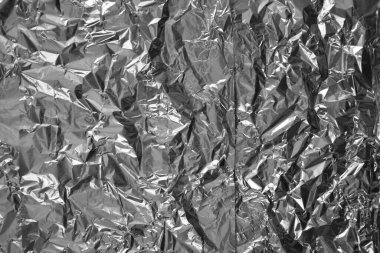 Parlak metalden işlenmiş gümüş folyo buruşmuş ambalaj malzemesi dokusu arka planı.
