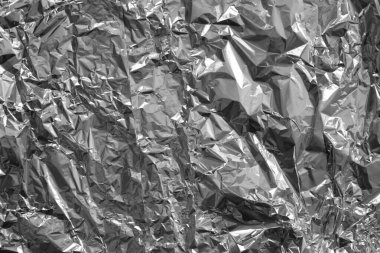 Parlak metalden işlenmiş gümüş folyo buruşmuş ambalaj malzemesi dokusu arka planı.