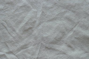 Arka plan olarak beyaz renkli gri tekstil peçetesi. Katlanmış dekoratif mutfak pamuğu havlusu kapat.