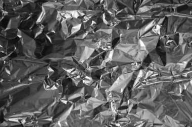 Parlak metalden işlenmiş gümüş folyo buruşmuş ambalaj malzemesi dokusu arka planı.