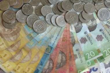 Ukraine money coins lying on mixed hryvnia banknotes, background. finance concept