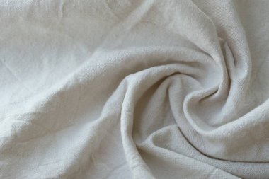 Arka plan olarak beyaz renkli gri tekstil peçetesi. Katlanmış dekoratif mutfak pamuğu havlusu kapat.