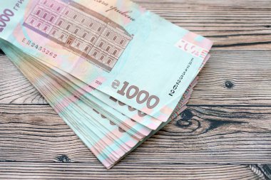 Ahşap arka planda modern tasarımı olan büyük miktarda Ukrayna yapımı 100 Hryvnia para faturası. Finansal konsept, iş ücretleri