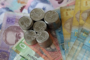 Birkaç yığın Ukrayna parası eski Hryvnia banknotlarının üzerinde yatıyor.