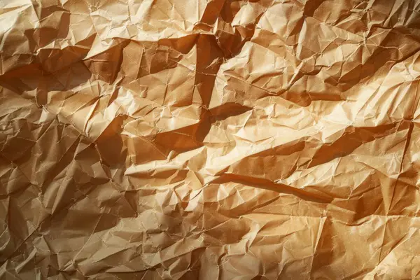 Buruşuk kahverengi kağıdın fotoğrafı. Kapatın. Arkaplan veya haritalama için arkaplan dokusu
