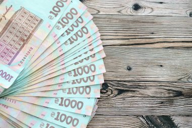 Ahşap arka planda modern tasarımı olan büyük miktarda Ukrayna yapımı 100 Hryvnia para faturası. Finansal konsept, iş ücretleri