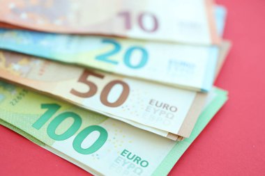 Büyük meblağda yüz, yirmi, on ve elli euro. Kırmızı arka planda. Yakın plan.