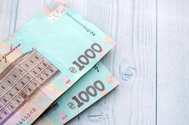 Beyaz ahşap masa üzerinde modern tasarımı olan büyük miktarda Ukrayna yapımı 100 Hryvnia para faturası. Finansal konsept, iş ücretleri