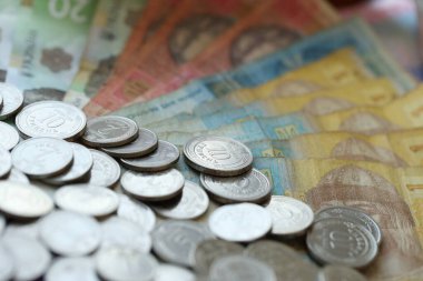 Ukraine money coins lying on mixed hryvnia banknotes, background. finance concept