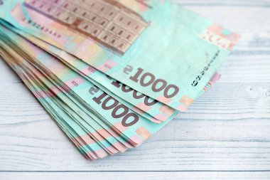 Beyaz ahşap masa üzerinde modern tasarımı olan büyük miktarda Ukrayna yapımı 100 Hryvnia para faturası. Finansal konsept, iş ücretleri