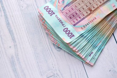 Beyaz ahşap masa üzerinde modern tasarımı olan büyük miktarda Ukrayna yapımı 100 Hryvnia para faturası. Finansal konsept, iş ücretleri