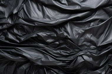 Siyah selofan çöp torbası dokusunun işlenmiş kolajı. Pankart, arkaplan veya 3B haritalama için doku