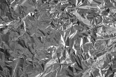 Parlak metalden işlenmiş gümüş folyo buruşmuş ambalaj malzemesi dokusu arka planı.