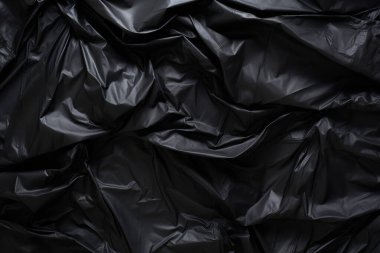 Siyah selofan çöp torbası dokusunun işlenmiş kolajı. Pankart, arkaplan veya 3B haritalama için doku