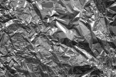Parlak metalden işlenmiş gümüş folyo buruşmuş ambalaj malzemesi dokusu arka planı.