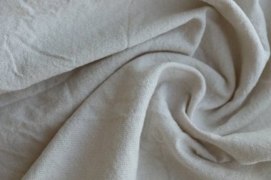 Arka plan olarak beyaz renkli gri tekstil peçetesi. Katlanmış dekoratif mutfak pamuğu havlusu kapat.