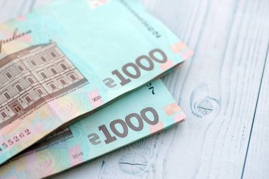 Beyaz ahşap masa üzerinde modern tasarımı olan büyük miktarda Ukrayna yapımı 100 Hryvnia para faturası. Finansal konsept, iş ücretleri