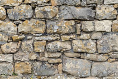 Eski gri ve kahverengi taş duvarın fotoğrafı. Arkaplan veya haritalama için arkaplan dokusu