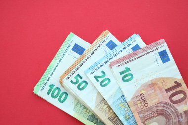 Büyük meblağda yüz, yirmi, on ve elli euro. Kırmızı arka planda. Yakın plan.