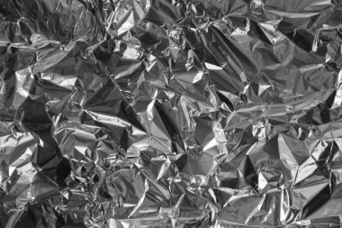Parlak metalden işlenmiş gümüş folyo buruşmuş ambalaj malzemesi dokusu arka planı.