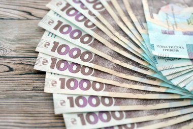 Ahşap arka planda modern tasarımı olan büyük miktarda Ukrayna yapımı 100 Hryvnia para faturası. Finansal konsept, iş ücretleri