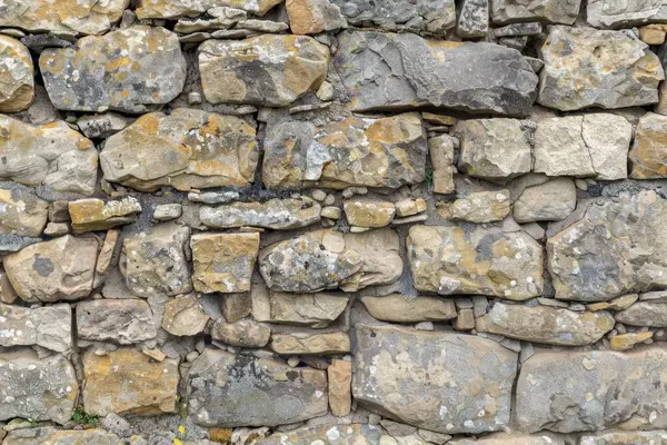 Eski gri ve kahverengi taş duvarın fotoğrafı. Arkaplan veya haritalama için arkaplan dokusu