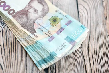 Ahşap arka planda modern tasarımı olan büyük miktarda Ukrayna yapımı 100 Hryvnia para faturası. Finansal konsept, iş ücretleri