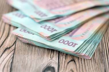 Ahşap arka planda modern tasarımı olan büyük miktarda Ukrayna yapımı 100 Hryvnia para faturası. Finansal konsept, iş ücretleri