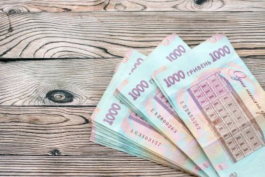 Ahşap arka planda modern tasarımı olan büyük miktarda Ukrayna yapımı 100 Hryvnia para faturası. Finansal konsept, iş ücretleri